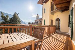 eine Holzterrasse mit einem Holztisch und einem Gebäude in der Unterkunft Residence Lena App 1 with Balcony in Tenno