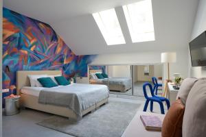 Butik Art Hotel في بودابست: غرفة نوم بسرير ودهان على الحائط