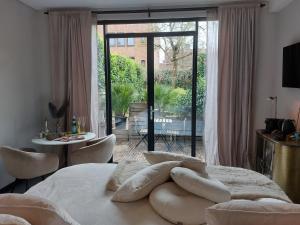 a bedroom with a bed with chairs and a large window at Saya Boutique Hotel in Amersfoort