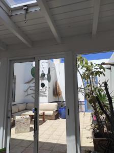 a patio door with a couch in a living room at Laylas Beach Art House in Cotillo
