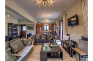 uma sala de estar com um sofá e uma mesa em Amazing Villa Amare with stunning views em Amárion