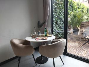 mesa y sillas en una habitación con ventana en Saya Boutique Hotel, en Amersfoort