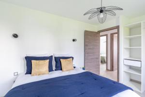 ein Schlafzimmer mit einem großen Bett mit blauen Kissen in der Unterkunft La Casalina in Combrit