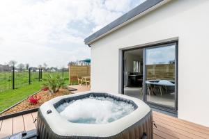 a hot tub on a deck next to a house at La Casalina in Combrit