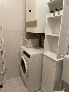 eine weiße Waschküche mit einer Waschmaschine in der Unterkunft Studio Vela in Izola
