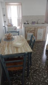 cocina con mesa y sillas y cocina con fregadero en Il Vallone, en Crispiano