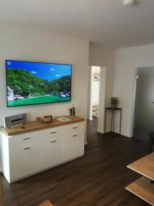 uma sala de estar com uma grande televisão de ecrã plano na parede em Ferienwohnung Pont an der Niers em Geldern