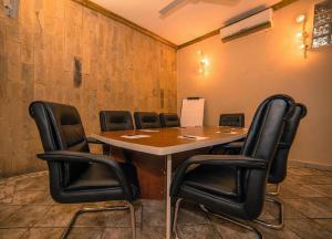 a conference room with a table and black chairs at Colosseum Boutique Hotel & Spa in Dar es Salaam