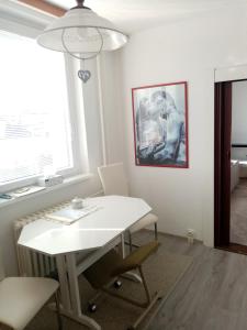 Biały stół i krzesła w pokoju z oknem w obiekcie Apartmán BlueA w Igławie