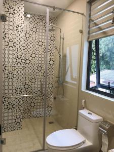 a bathroom with a toilet and a glass shower at Lynh's Villa in Cat Ba