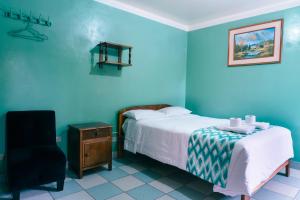 1 dormitorio azul con 1 cama y 1 silla en ALPA KASA CHACHAPOYAS, en Chachapoyas