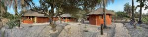 un par de casas pequeñas con árboles en un campo en Bégué Lodge, en Dinouar