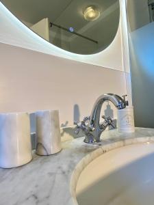 a bathroom sink with a faucet and a mirror at Gronocottage in Bad Harzburg +42 photos