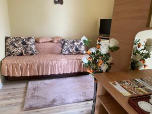 a living room with a pink couch and a table at Vila La Famiglia in Eforie Nord