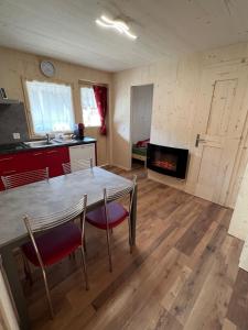 a kitchen and living room with a table and chairs at Bungalow Li Presi in Camping Cavresc, Via dal Cavresc 1, 7746 Le Prese-Poschiavo in Poschiavo