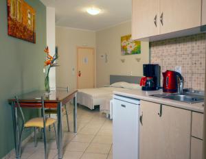 a kitchen with a table and a room with a bed at Hotel Loukas Vrachos in Paralia Vrachou