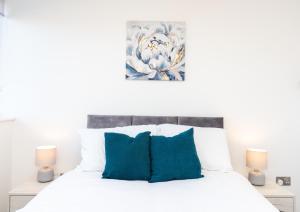 a bedroom with a white bed with blue pillows at Modern Apartments in Kings Lynn with Free Wi-Fi in King's Lynn