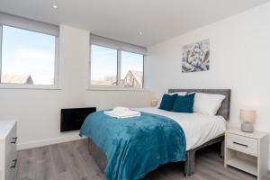 een witte slaapkamer met een bed en 2 ramen bij Modern Apartments in Kings Lynn with Free Wi-Fi in Kings Lynn