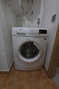 a white washing machine in a corner of a room at Lo raconet in L'Ampolla