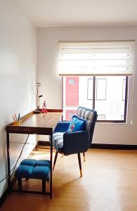 sala de estar con mesa, silla y escritorio en Relaxing 1-Bedroom Condo Unit (by Lee Portum), en Marilao