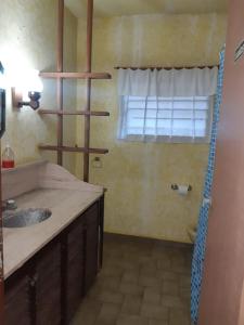 baño con lavabo y ventana en Hotel Duclout Confort Inn en Monte Grande