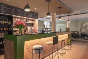 a restaurant with a green bar with stools at the niu Mill in Cologne