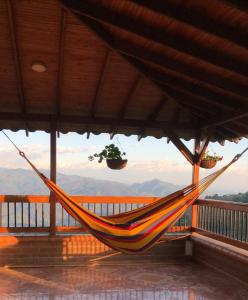 un balcón con hamaca y vistas a las montañas en Hotel San Felipe Belalcazar 