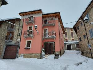 a pink building with snow in front of it at LA MONTADARIA in Zavattarello