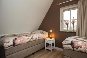 um quarto com 2 camas e uma janela em 't sfeeruus em Serooskerke