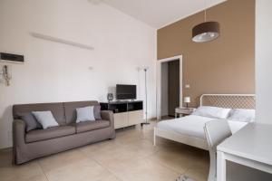 ein Wohnzimmer mit einem Sofa und einem TV in der Unterkunft Palazzina Carracci in Bologna