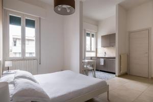 een witte slaapkamer met een bed en een keuken bij Palazzina Carracci in Bologna