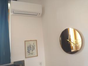 a clock on a white wall with a air conditioner at Apartmán s klavírem in Lednice