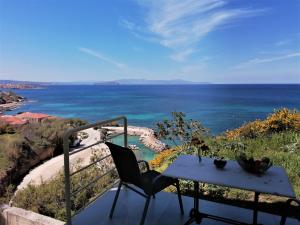 einen Tisch und einen Stuhl auf einem Balkon mit Meerblick in der Unterkunft Emerald Apartment Halepa in Chania