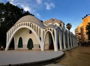 a white building with an archway on a street at Piso céntrico con Parking a 20min de Barcelona in Terrassa