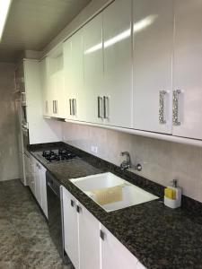 a kitchen with white cabinets and a sink at Piso céntrico con Parking a 20min de Barcelona in Terrassa