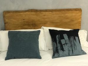 a bed with two pillows and a wooden headboard at Piso céntrico con Parking a 20min de Barcelona in Terrassa
