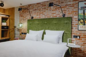 - une chambre avec un lit blanc et un mur en briques dans l'établissement ONE66 Hotel, à Ljubljana