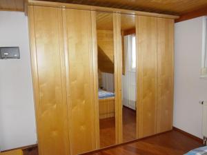 a wooden cabinet in a room with a bedroom at Ferienwohnung Zweilinden in Steinen