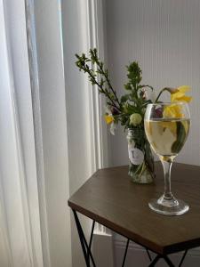 un jarrón de flores y una copa de vino sobre una mesa en The Upper Largo Hotel & Restaurant, en Lundin Links
