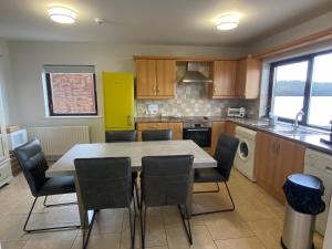 a kitchen with a table and chairs in it at Tullybay Holiday Homes in Tully