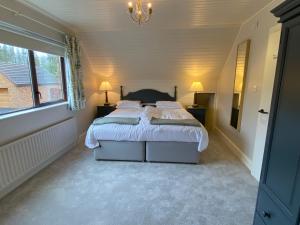 um quarto com uma cama grande com lençóis brancos e almofadas em Tullybay Holiday Homes em Tully
