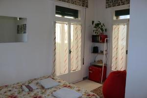 1 dormitorio con 1 cama y 1 silla roja en Venezia lovely rooms, en Lido de Venecia