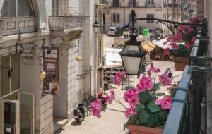 einen Blick über eine Stadtstraße mit rosa Blumen in der Unterkunft Residencial Florescente in Lissabon