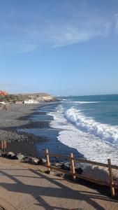 una spiaggia con recinzione in legno e l'oceano di Edificio Neptuno ad Adeje