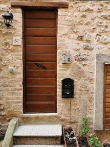 una porta in legno sul lato di un edificio in pietra di Torre degli Arduini, San Giacomo, Spoleto a San Giacomo