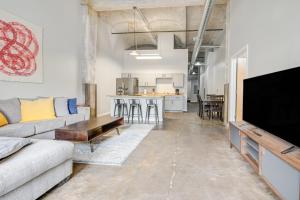 a living room with a couch and a flat screen tv at 3BR Luxury Historic Loft with Gym by ENVITAE in Kansas City