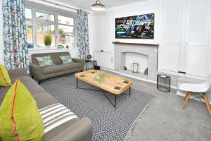 a living room with a couch and a fireplace at London House by YourStays in Stoke on Trent