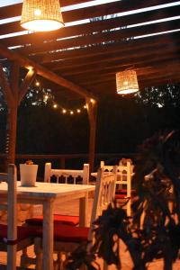 a table and chairs under a pergola with lights at Casa KiSi Cottage, Rural Boutique Bed & Breakfast in Málaga