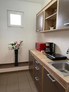 a kitchen with a sink and a vase of flowers at Vila La Famiglia in Eforie Nord