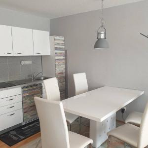 a kitchen with a white table and white chairs at Ferienwohnung Mia in Sankt Englmar